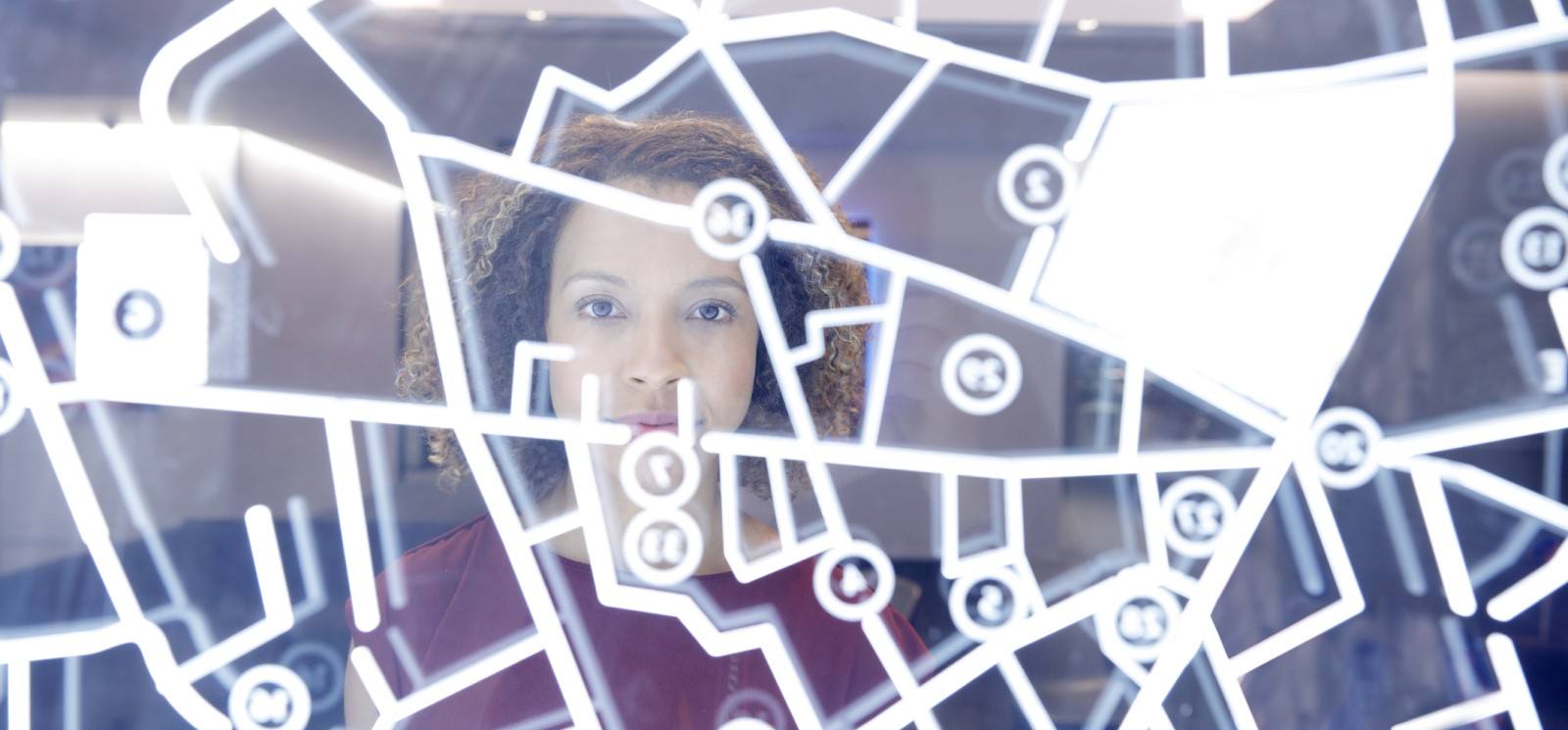 Woman staring at a digital display with multiple street paths