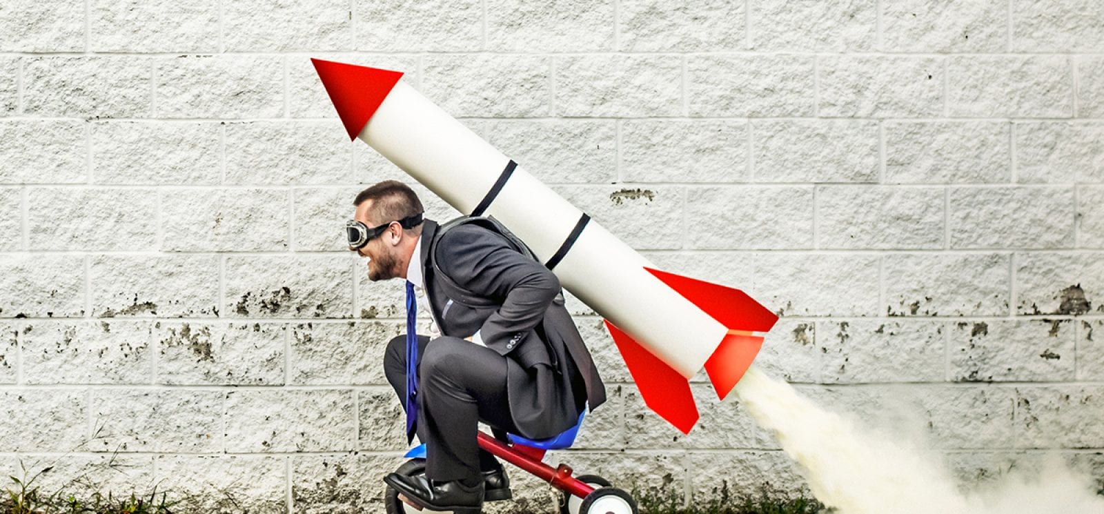 Man in kids tricycle with propelled by rocket