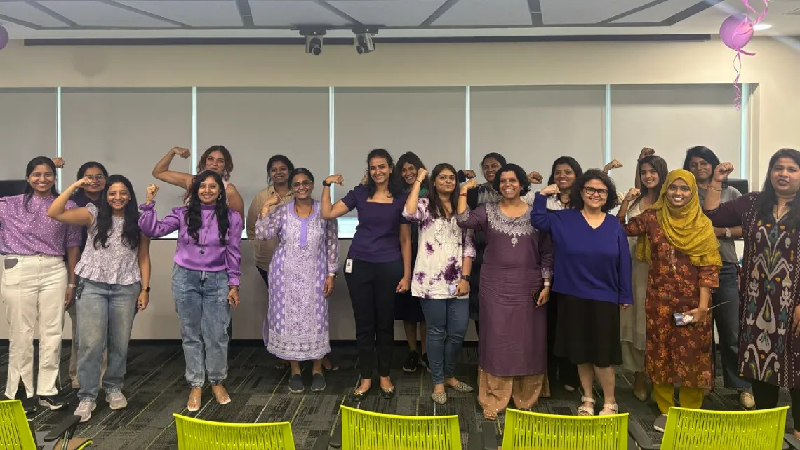 employees at a company event in one of the progress offices posing for a group photo