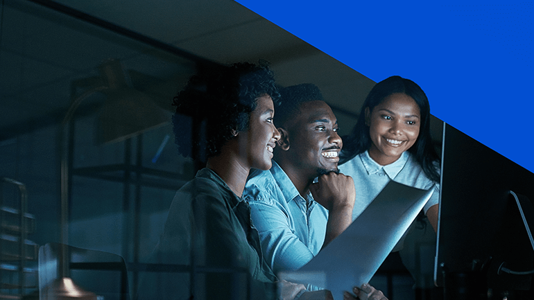 three people talking to each other and looking at a screen