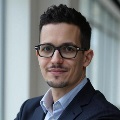 Headshot of man with dark hair and glasses